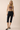 Abar Top taupe ribbed graphic tank styled with dark jeans and heels, showing fitted silhouette and cropped length in full-body studio look.