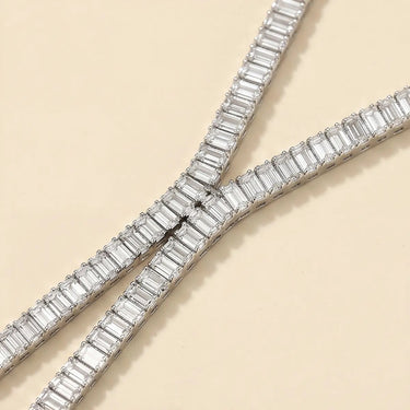 Adele necklace in silver featuring emerald-cut baguette stones in a refined tennis-style setting on a neutral background.