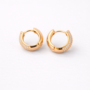 Agata Huggie Earrings gold version close-up showing small hoop earrings with pavé zirconia stones on outer edge on light neutral background with soft shadow