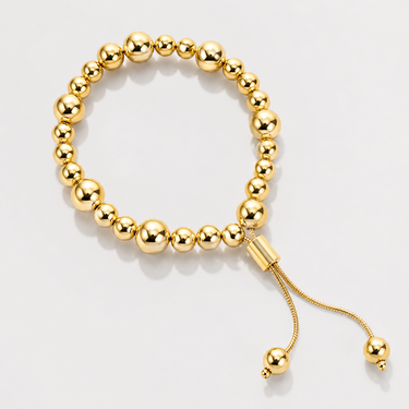 Aka Bracelet gold beaded bracelet with polished mirror finish beads and adjustable slider closure on neutral background