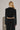 Woman wearing black Akima cropped velvet jacket with matching pants, full look back view.