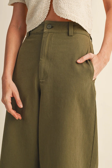Altea Pant – relaxed wide-leg pants in olive cotton with high-rise waist, front view on model.