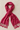 Fuchsia pashmina scarf with soft fringe edges folded on beige linen background.