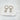 A pair of gold-plated huggie earrings with star charms attached, displayed on a white surface.