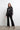 Front view of Astra Crystal Blouse in black satin, crystal-embellished collar and cuffs, worn with slit-hem black pants.