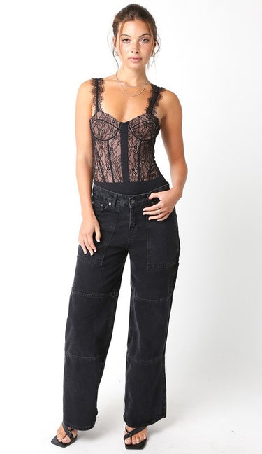 Atta Bodysuit full body look featuring black lace corset bodysuit paired with black jeans, showing flattering structured fit and lingerie-inspired detailing designed for parties and after-dark styling.