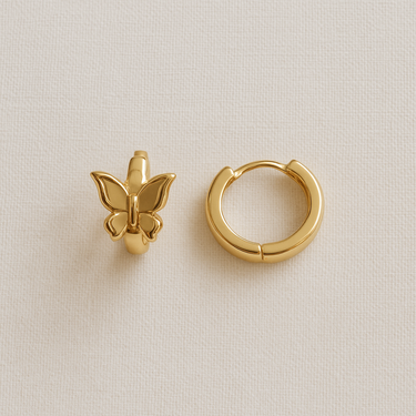 Avaia Huggie Earrings — gold plated butterfly huggie earrings on neutral linen background, polished and elegant jewelry by Matte.