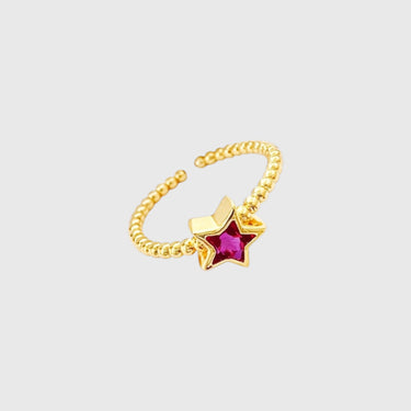 Gold beaded ring with pink star-shaped crystal on white marble surface – Belma Ring by Matte.