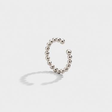 Silver beaded ear cuff on a light gray background