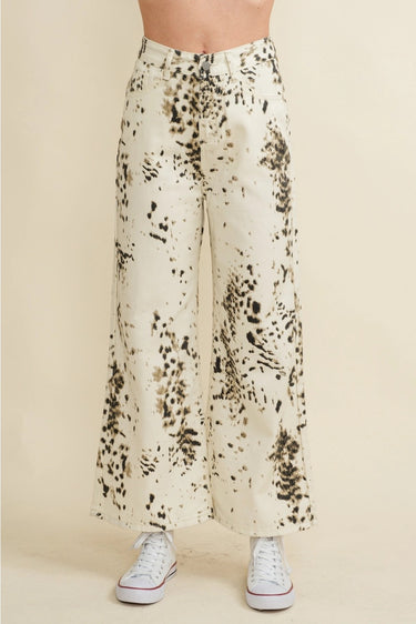 Biz Pants wide-leg ivory trousers with dark abstract splatter print, high-rise fit and relaxed drape, shown from waist down styled with white sneakers on neutral studio background.