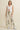 Biz Pants full body outfit photo featuring high-rise wide-leg printed ivory trousers with dark abstract pattern, styled with a fitted white tank top and sneakers for an effortless casual-chic look.