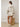Woman wearing boxy cropped hoodie and matching mini skirt in soft neutral tones, back view.