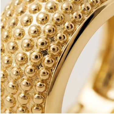 Close-up detail of Brussels Huggie Earrings featuring textured gold bead detailing and polished gold hoop finish in macro jewelry photography style