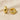 Gold domed huggie earrings on beige linen backdrop — Cairo Huggie Earrings by Matte.