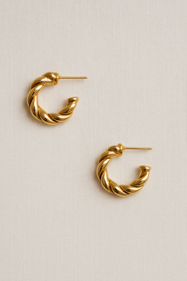 Calla Hoop Earrings — twisted gold plated hoops with sculptural shape on neutral linen background, polished and elegant jewelry by Matte.