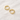 Cassis Huggie Earrings – small polished gold huggie hoop earrings with a smooth minimalist design, photographed on a soft neutral background.
