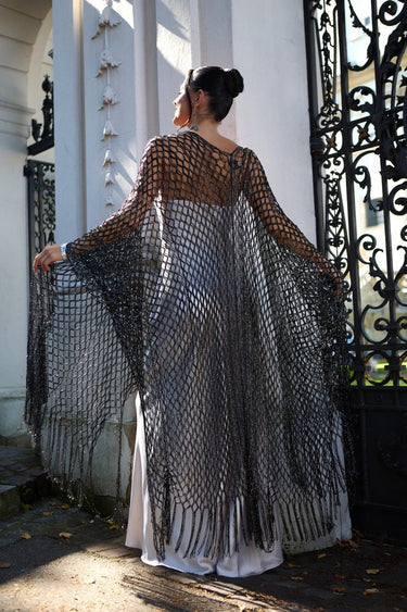 Chalat Kimono worn by model, back view outdoors, highlighting sheer open-knit texture and long fringe drape
