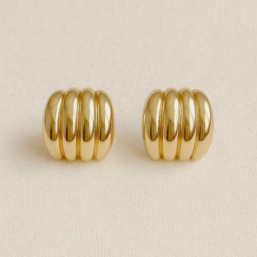 Clarté Stud Earrings, gold ribbed stud earrings with stacked band design and polished mirror finish, photographed on white linen background with soft editorial lighting