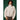 Woman wearing light neutral quilted puff jacket with high neck and elastic cuffs against dark green background.