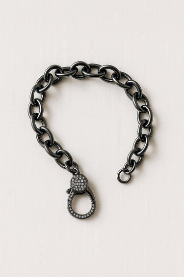 Coil Bracelet — black mirrored chain bracelet with pavé crystal clasp on linen background, bold and modern statement piece by Matte.