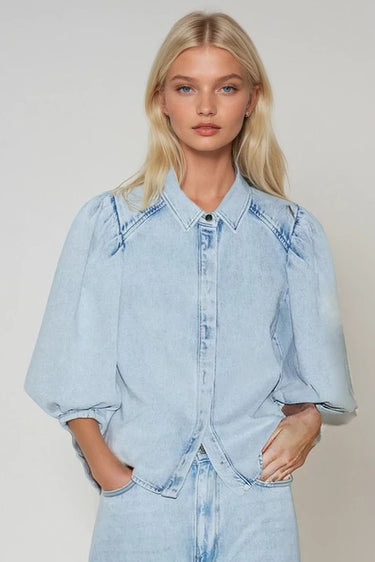 Model wearing the Corsica light-wash denim blouse with volume sleeves.