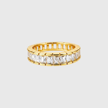 Darsy Ring gold eternity band with baguette-cut stones on silver surface