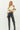 Model wearing black faux leather straight-leg pants with boots, front view.