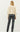 Model wearing black faux leather straight-leg pants with boots, back view.