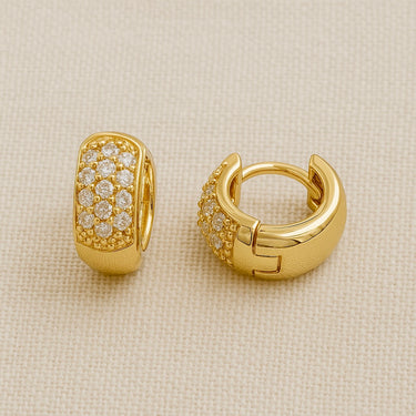 Elliot Huggie Earrings, gold huggie hoop earrings with pavé-set front and polished mirror finish, photographed on white linen background with soft editorial lighting.