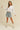 Model styling white Essential Long Sleeve Tee by Matte tucked into blue denim jeans