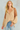 Woman wearing Evalina Blouse in beige silk with embroidered animal-texture sleeves, styled with denim jeans.