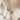 Faiza gold huggie earrings on a beige fabric background