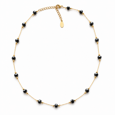 Flur Necklace gold plated necklace with black faceted beads on neutral background, showing delicate chain, warm tones, and adjustable extender