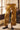 Close-up of Galicia Pant showing oversized ivory floral print on mustard yellow fabric, front patch pockets, and wide-leg cut.