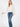 Model wearing the Giselle Blouse in white — semi-sheer, lightweight button-down with voluminous sleeves, styled with denim jeans against a neutral background.