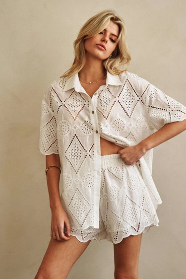 Godeth Blouse front view highlighting crisp white eyelet fabric, button-front shirt shape, and feminine scalloped edges