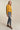 Woman posing in mustard yellow cropped coat with modern tailored style, perfect for fall layering