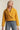 Side view of woman in mustard cropped coat with boxy silhouette