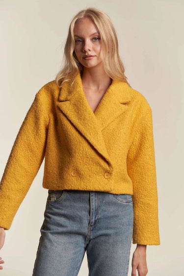 Mustard cropped coat paired with light blue jeans, casual chic look