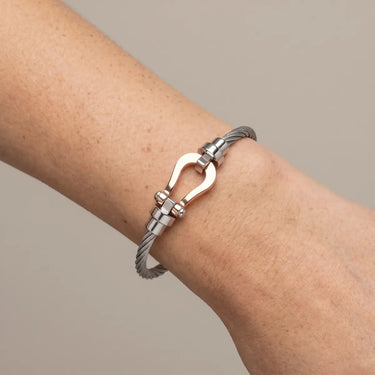 Haddy Bangle Bracelet silver twisted cable bracelet worn on wrist with polished horseshoe clasp detail, modern stainless steel cuff design with sleek luxury finish and minimalist styling.**
