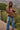 Woman wearing oversized knit sweater with American flag design, styled with jeans outdoors.
