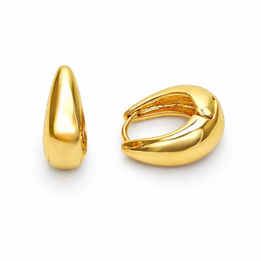 Higo Huggie Earrings chunky gold huggies with smooth sculptural finish isolated on light background