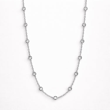 Iki Necklace silver zirconia version flat lay with evenly spaced crystal stones on silver chain displayed on clean editorial background.