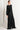 Woman wearing black pants with button details against a white background