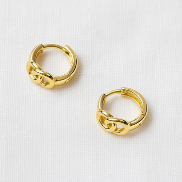 Ligne Huggie Earrings, gold huggie hoop earrings with sculpted chain link design and polished mirror finish, photographed on white linen background with soft editorial lighting.
