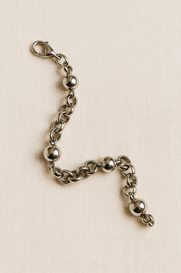 Loopa Bracelet — sculptural silver bracelet with interlinked loops and polished spheres on linen background, modern minimalist jewelry by Matte.