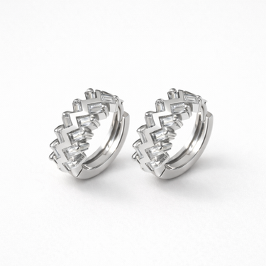 Pair of Magal silver huggie earrings with geometric stone design on a white background by Matte