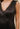Model wearing Maira Asymmetrical Dress in black satin, showing sleeveless fit.