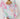 Woman wearing Maranola Sarong in pink tropical print, draped as a beach wrap over swimwear.