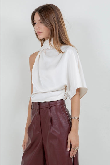 Maratea Blouse worn by model, angled view, showing fluid drape and modern sleeveless silhouette.